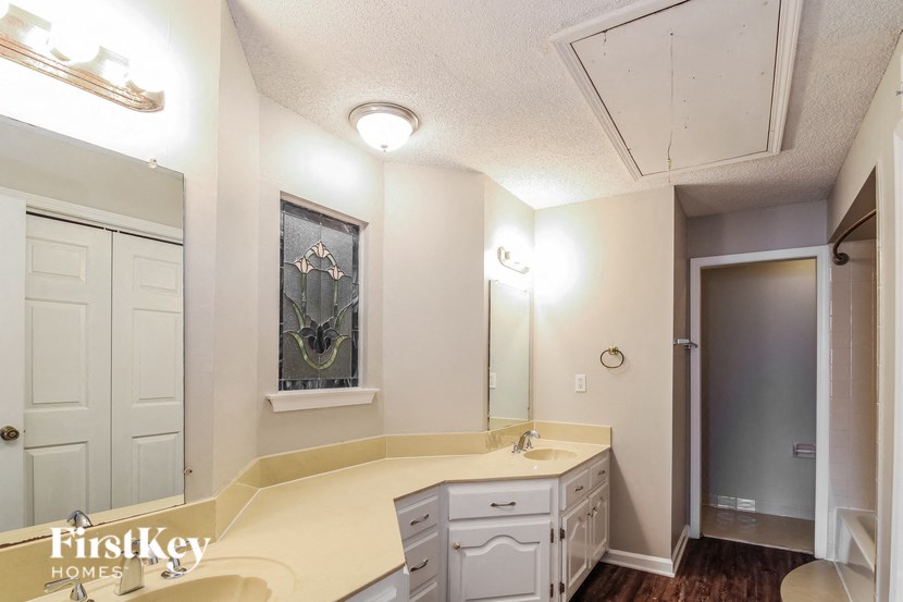 a bathroom with white cabinets and a sink and a mirror