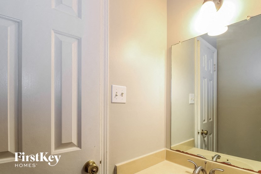 the bathroom has a large mirror and a sink