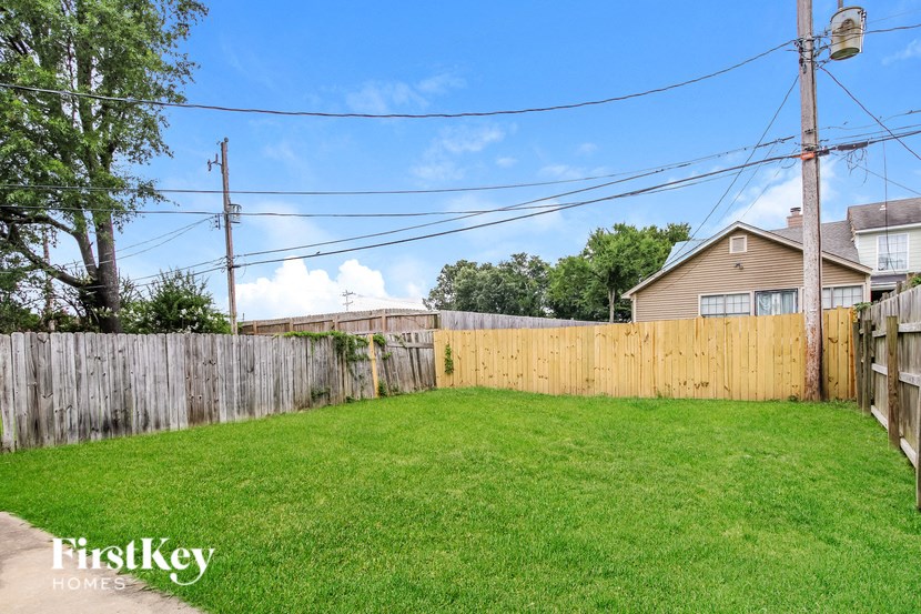 a fenced in backyard with a wooden fence