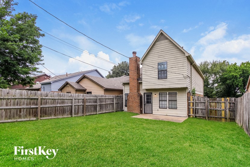 a backyard with a wooden fence and a house