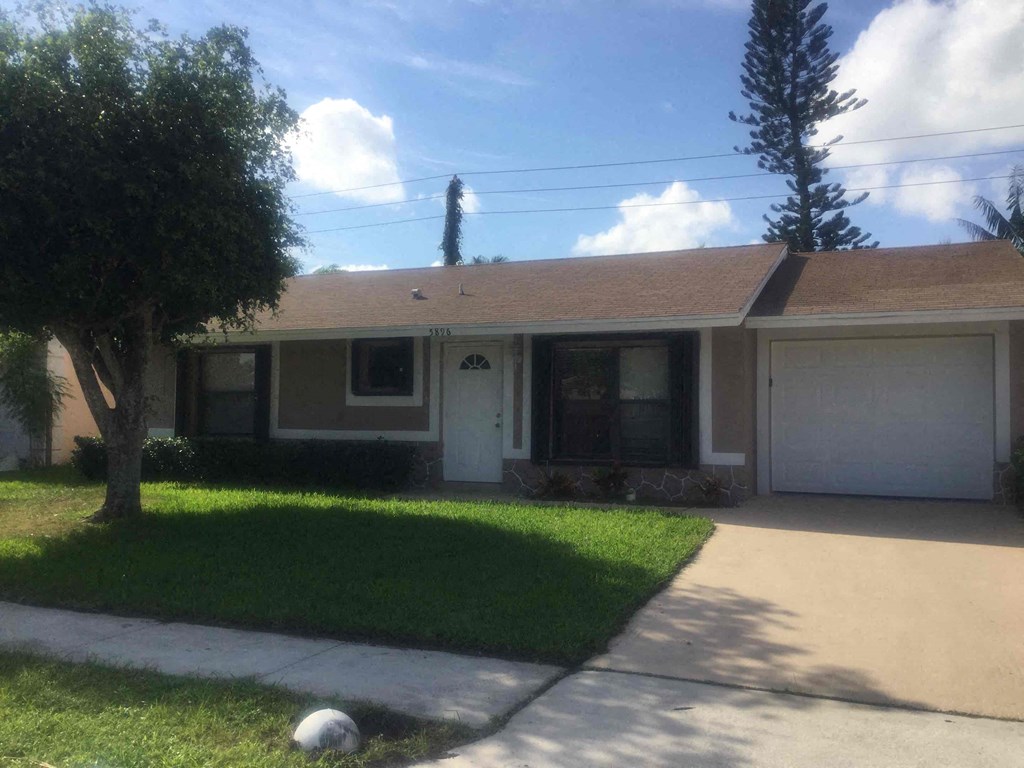 A house with a brown roof and a white garage door.