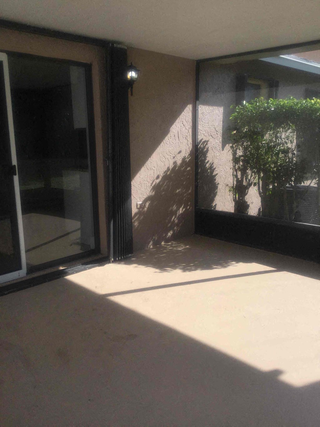A room with a sliding glass door and a wall-mounted light fixture.