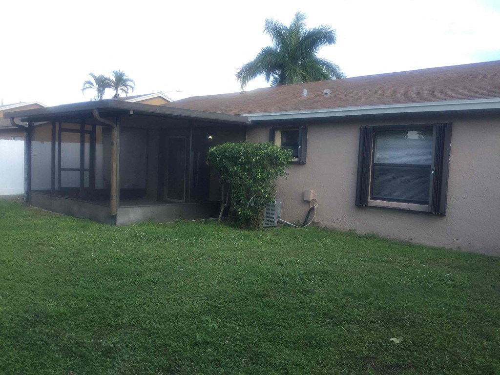 A house with a brown roof and a green lawn.