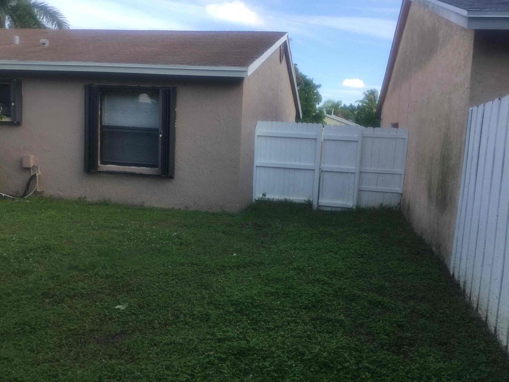 A white fence is in front of a house.