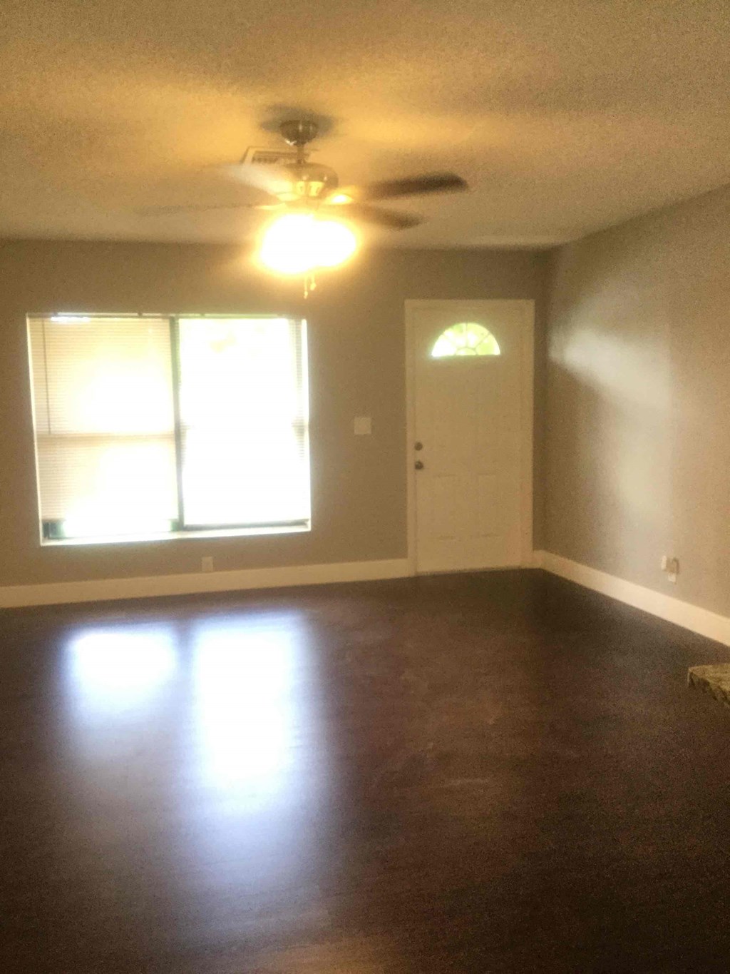 A room with a ceiling fan and a door.