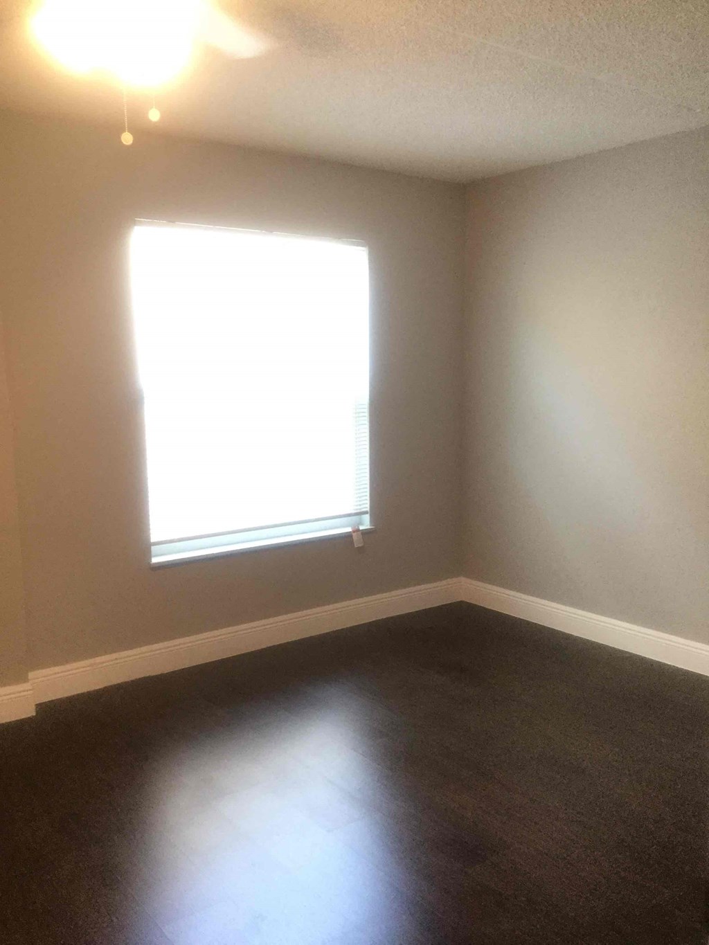 A room with a window and a ceiling fan.