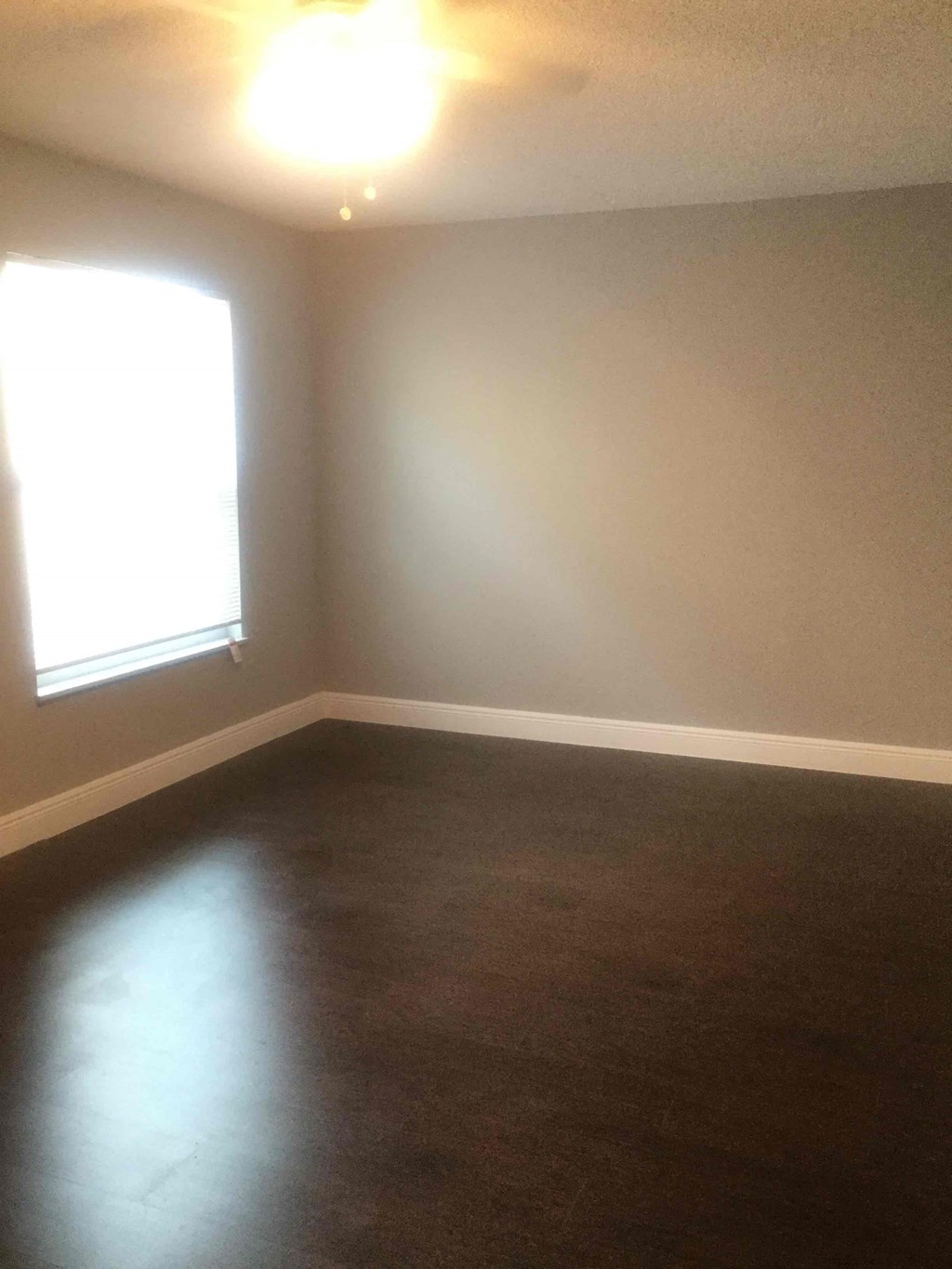 A room with a window and a light on the ceiling.