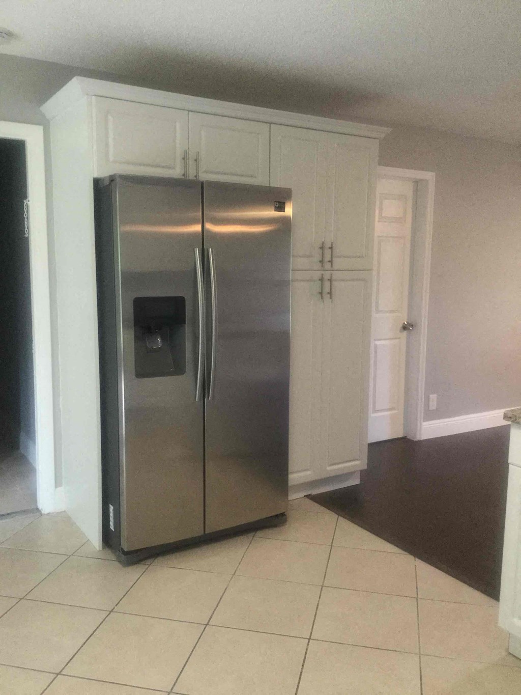 A stainless steel refrigerator in a kitchen.