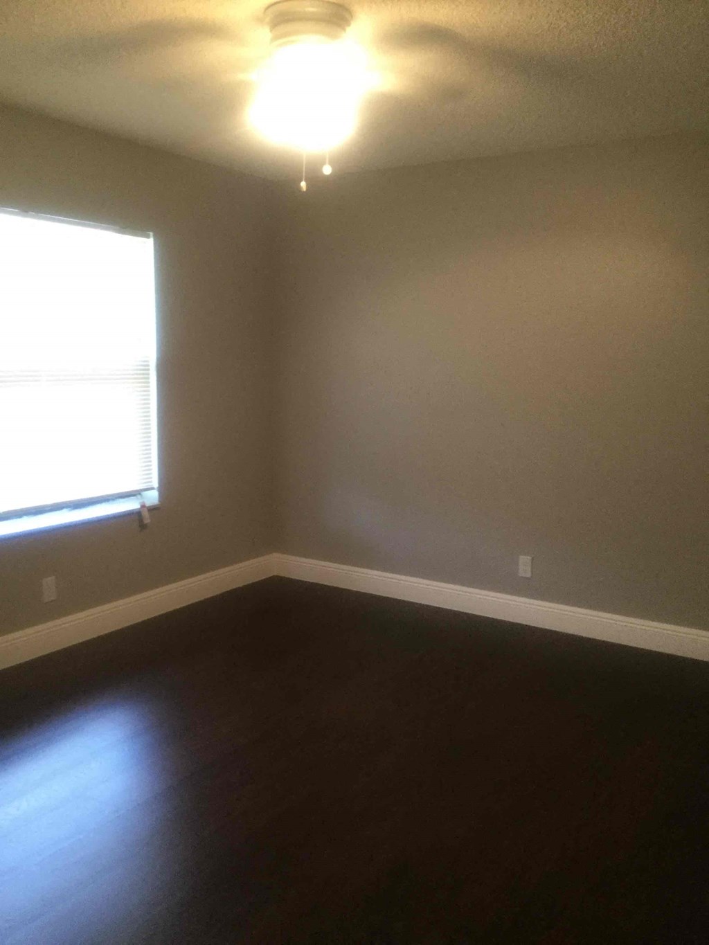 A room with a window and a ceiling light.