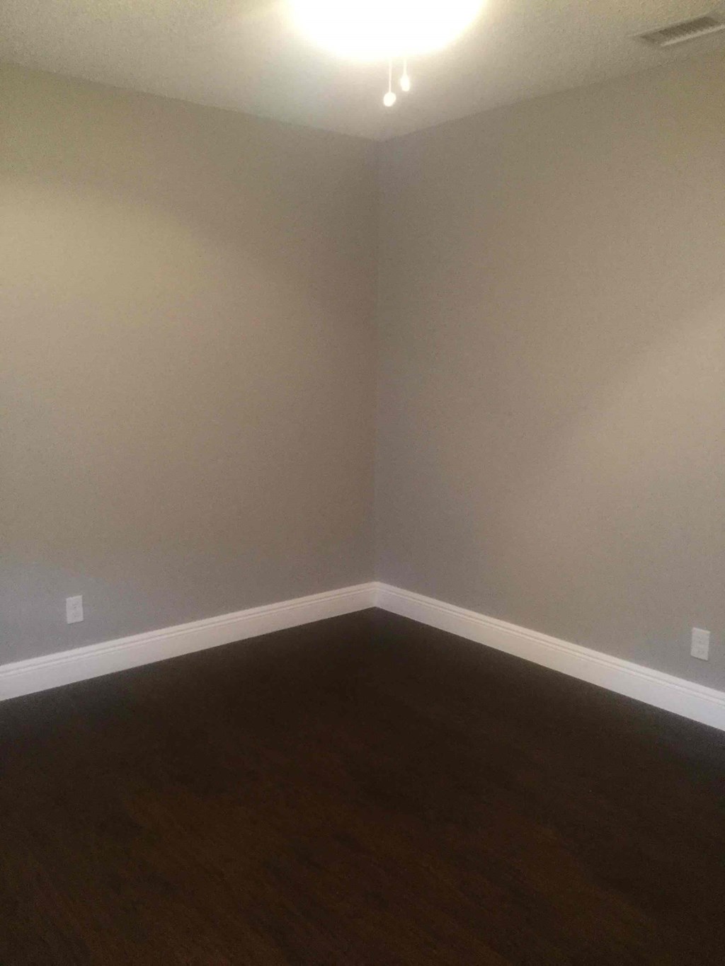 A room with a wooden floor and white walls.