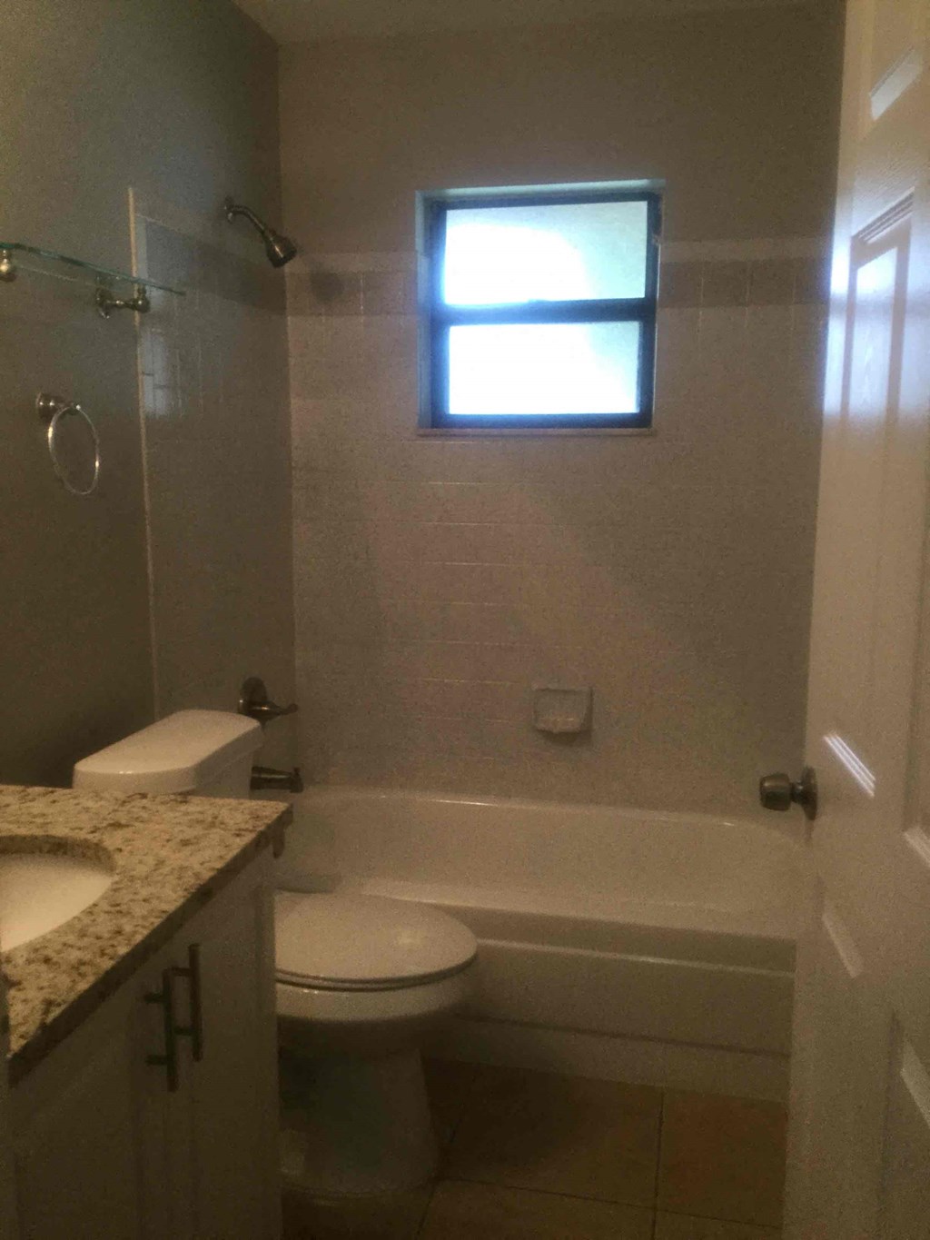 A small bathroom with a toilet, sink, and tub.