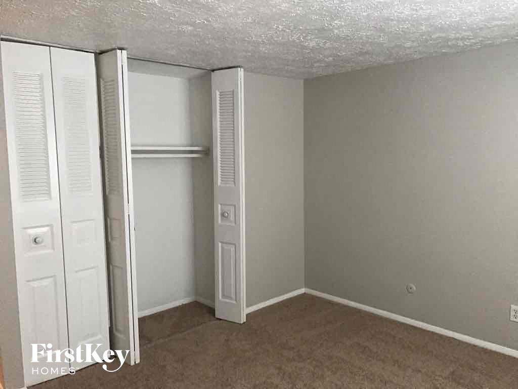 an empty bedroom with a closet and a wardrobe