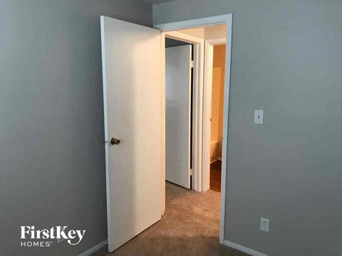 a bedroom door open to a hallway with a closet