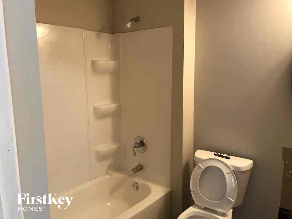 a bathroom with a toilet and a tub and a sink