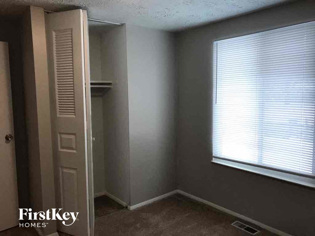 a small room with a large window and a closet