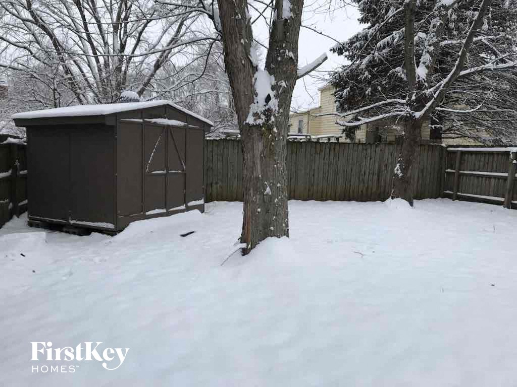 a shed in a backyard in the snow