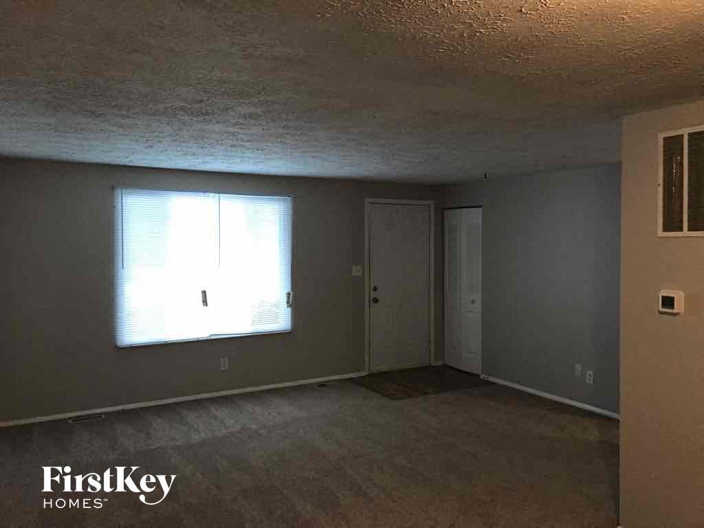 an empty living room with a window and a door