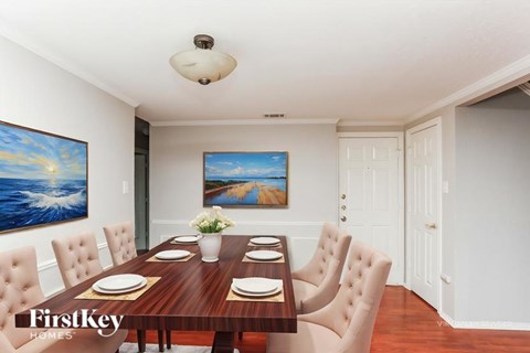 A dining room with a wooden table set for six.