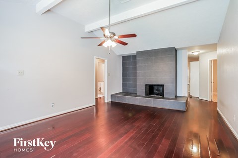 A spacious living room with a fireplace and wood flooring.