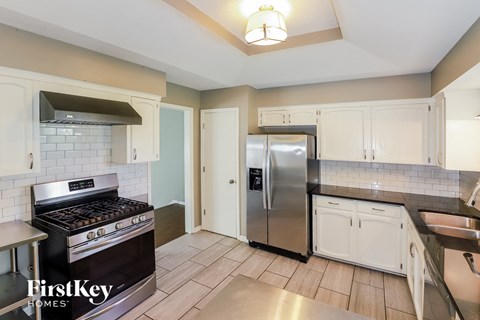 a kitchen with stainless steel appliances and white cabinets
