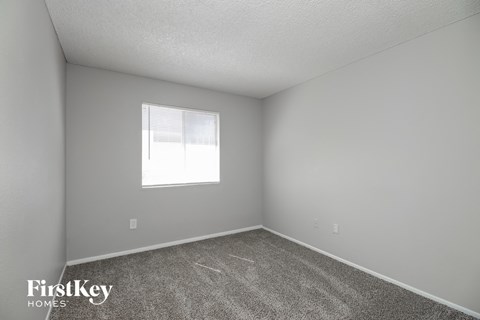 a bedroom with carpet and a window