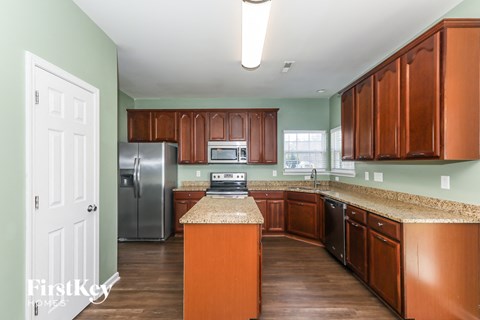 a kitchen with wooden cabinets and granite counter tops and stainless steel appliances