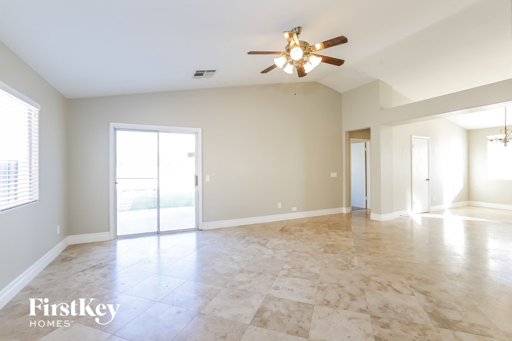 an empty living room with a ceiling fan