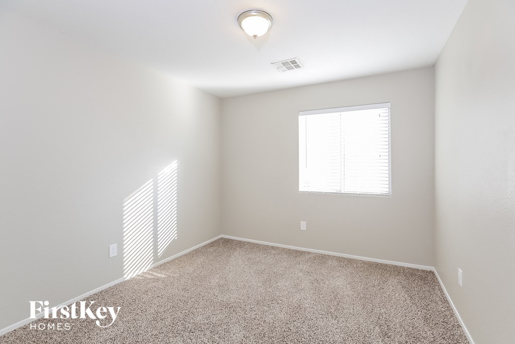 a spacious room with carpet and a window