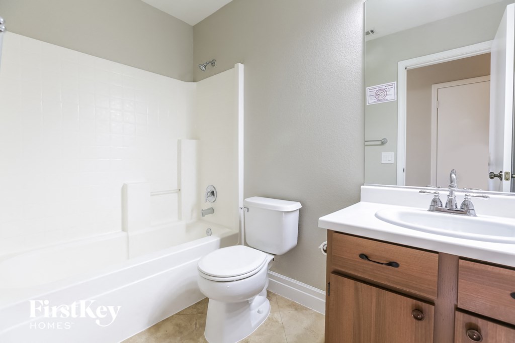 a bathroom with a toilet sink and tub and a mirror