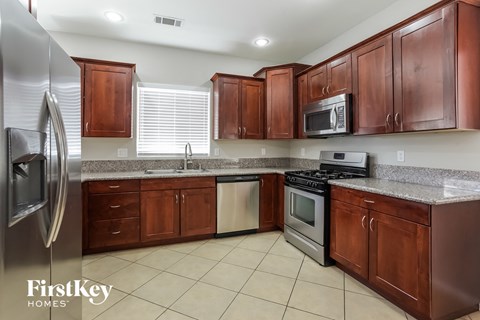 A kitchen with brown cabinets and a stainless steel refrigerator.