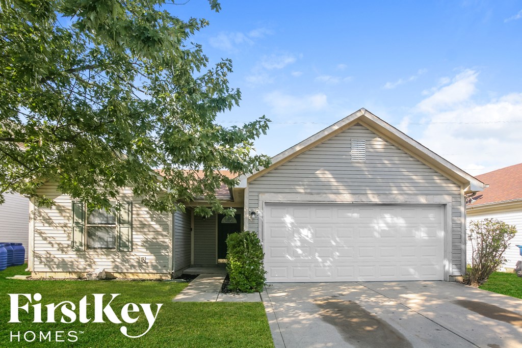 a white house with a white garage door and a green lawn