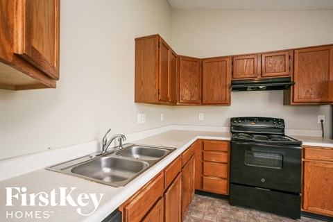 a kitchen with wood cabinets and black appliances and a sink