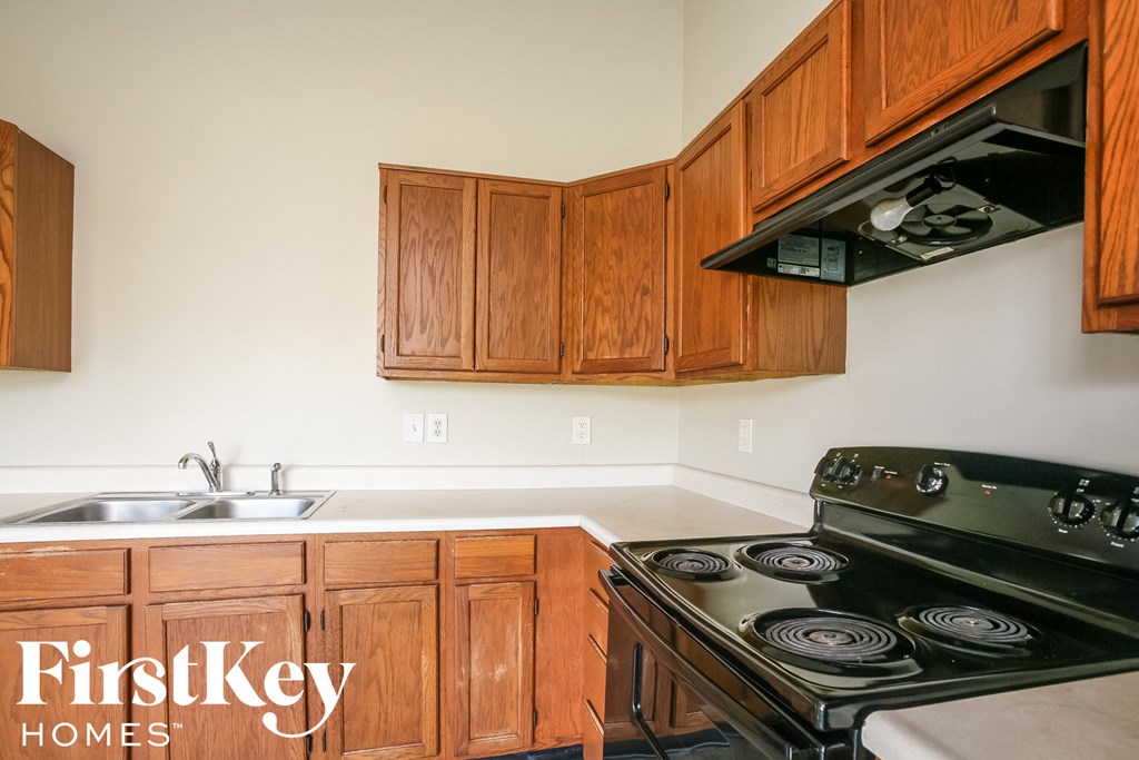 a kitchen with wood cabinets and a stove and a sink