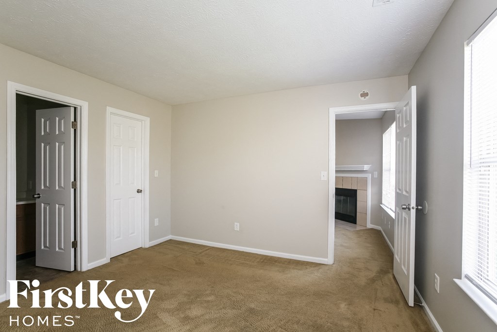 a living room with a carpeted floor and a door to a fireplace