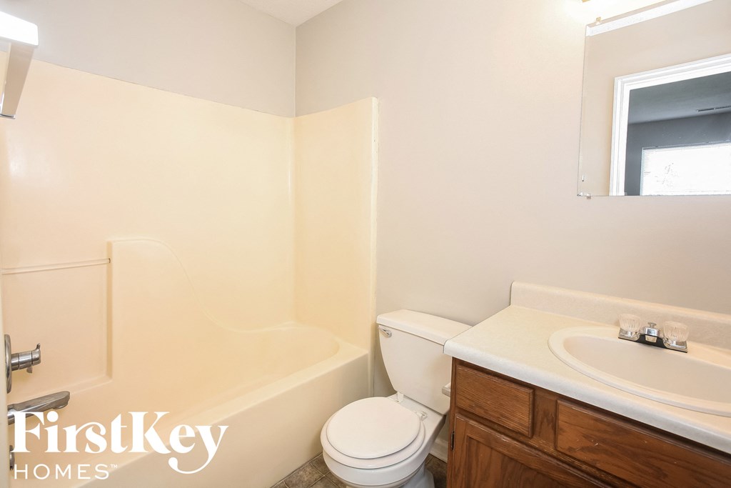 a bathroom with a toilet and a sink and a bath tub