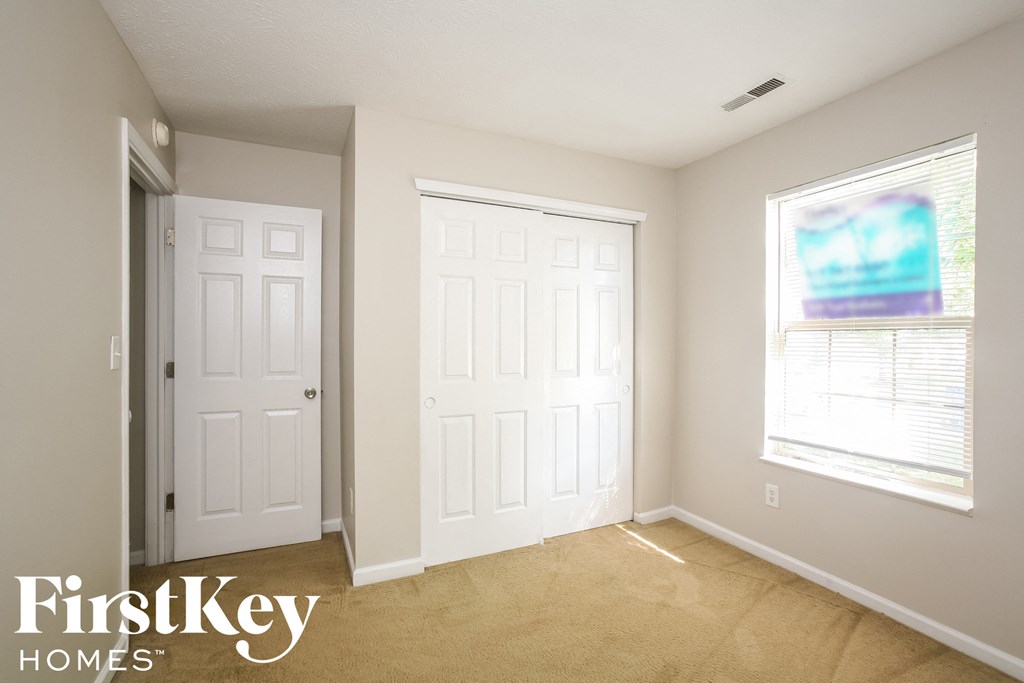 a bedroom with two white doors and a window