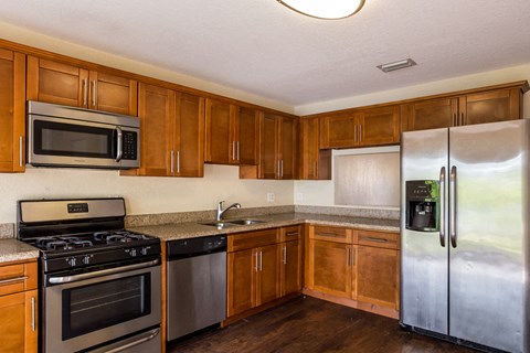 a kitchen with stainless steel appliances and wooden cabinets