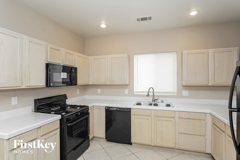a white kitchen with black appliances and white counter tops