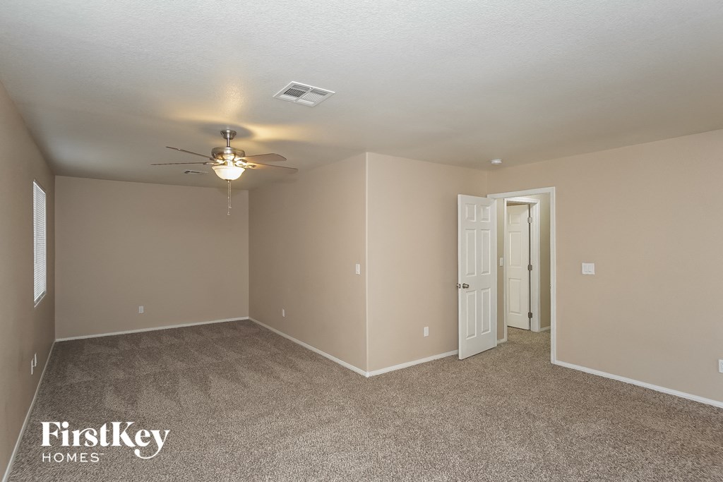 the living room of an empty house with a ceiling fan