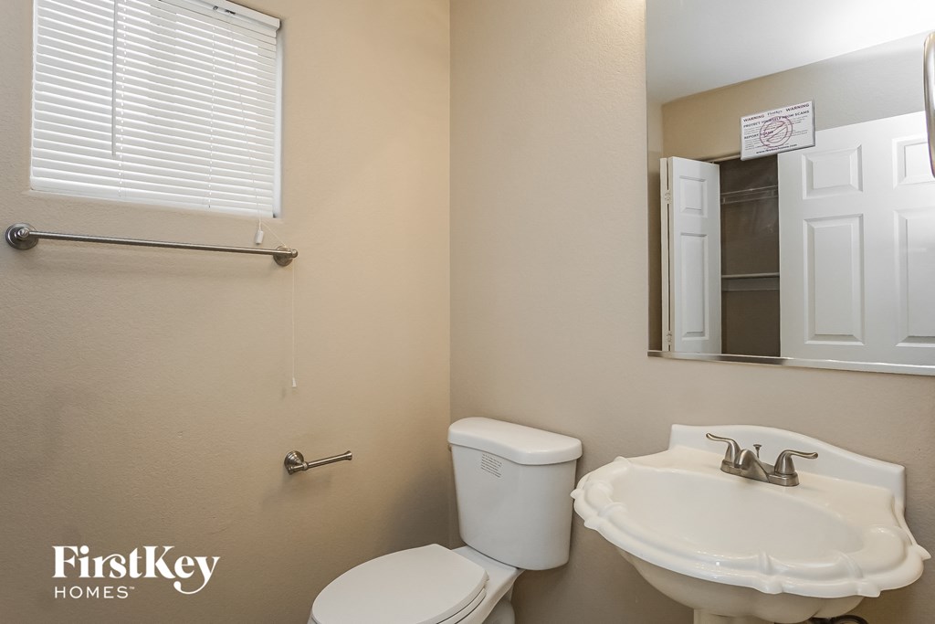 a bathroom with a sink and a toilet and a mirror