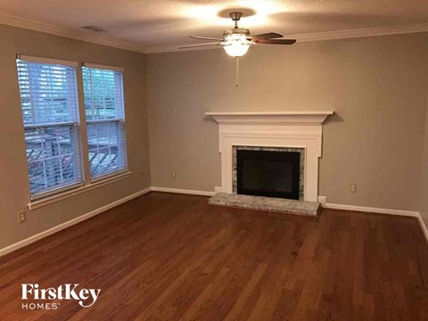 a living room with a fireplace and a ceiling fan
