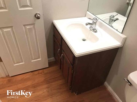 a bathroom with a sink and a mirror and a door