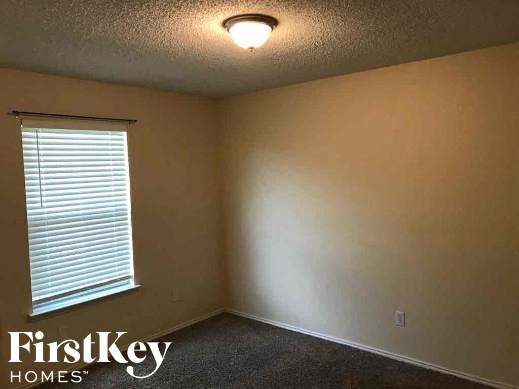 an empty room with a window and a light on the ceiling