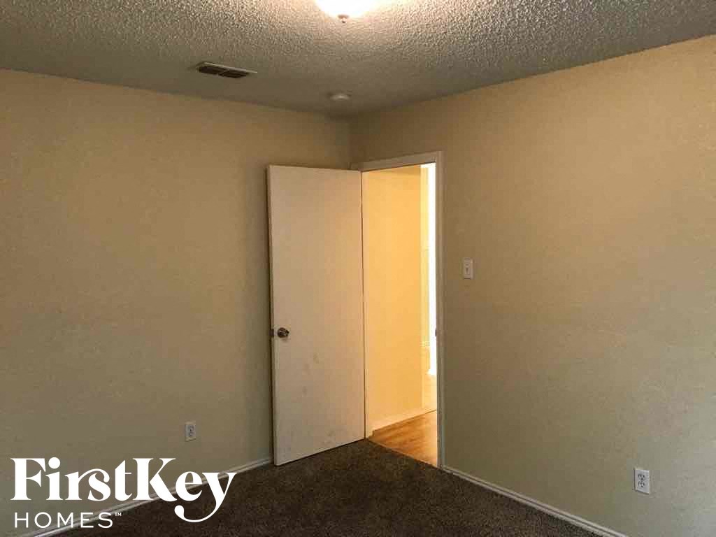 an empty room with a door to a closet