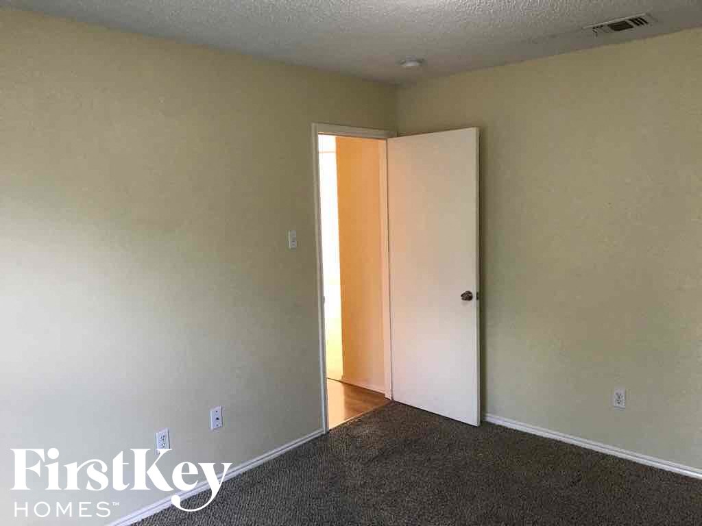 an empty living room with a door to a closet