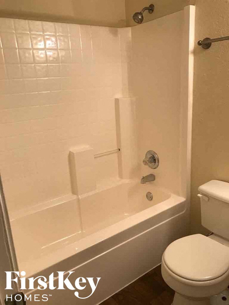 a white bathroom with a tub and a toilet