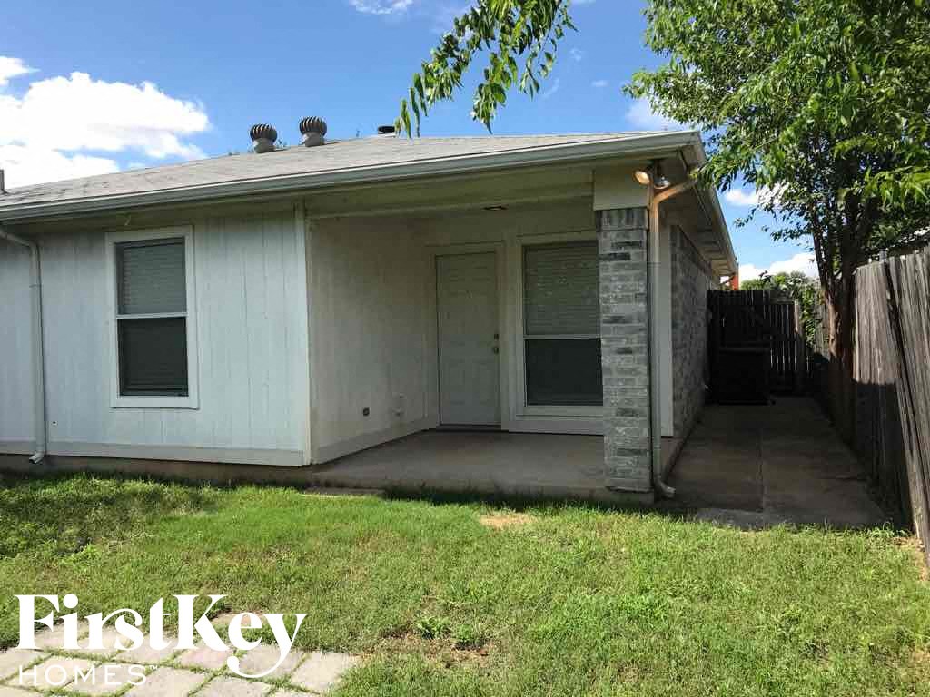 a small white house with a porch and a yard