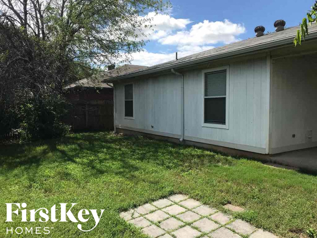 the backyard of a house with a lawn and a sidewalk