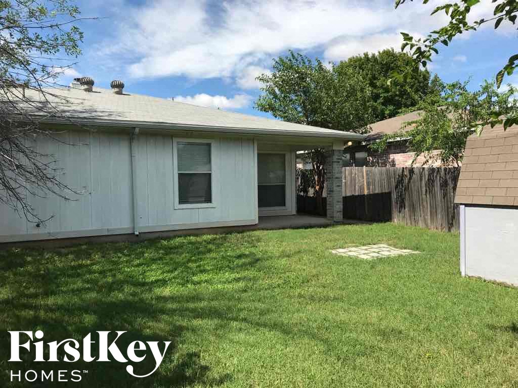 a backyard with a house and a yard with grass