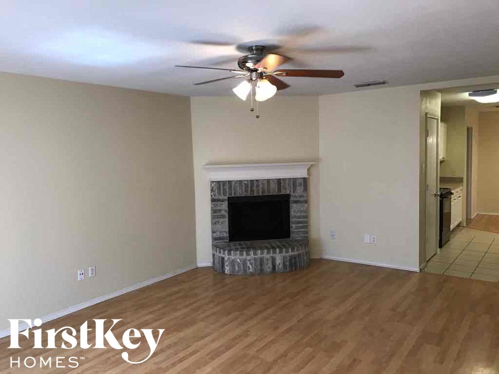 a living room with a fireplace and a ceiling fan
